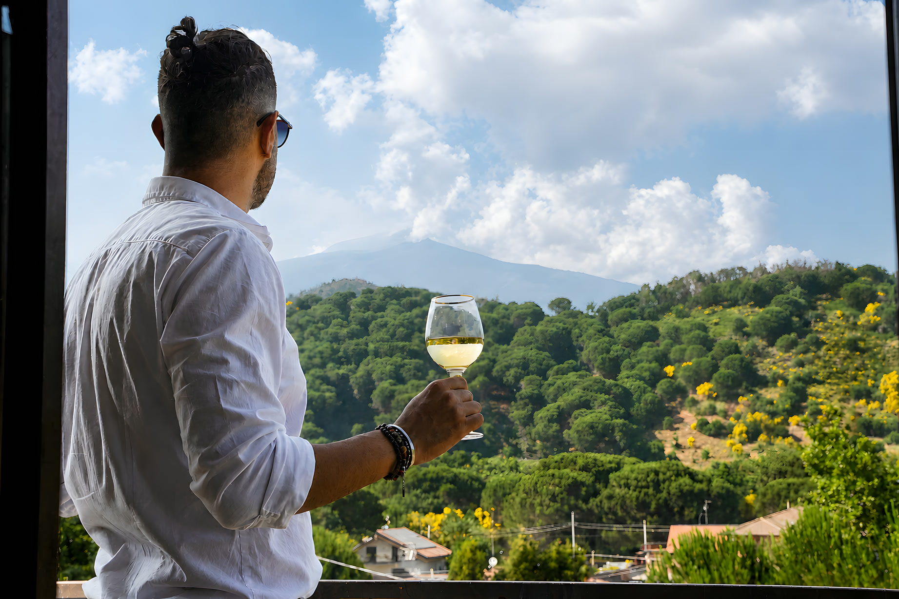Due calici di vino sul balcone della villa, il verde del versante intorno