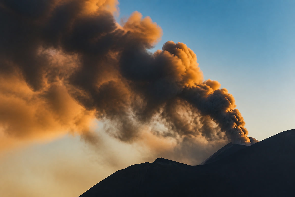 Pennacchio di fumo del cratere illuminato dalla luce calda della sera