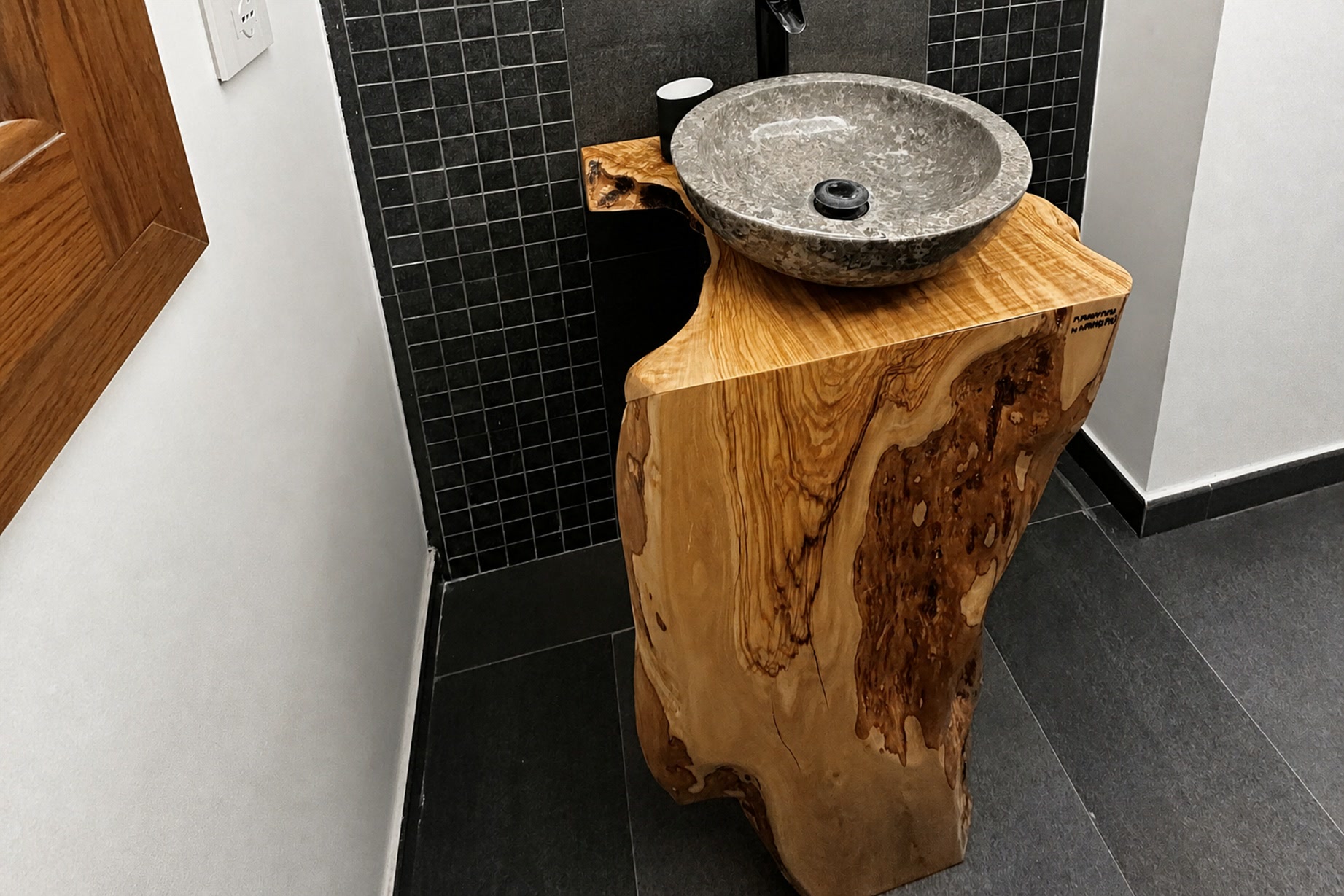 Il bagno della suite: specchio tondo su parete a mosaico scuro