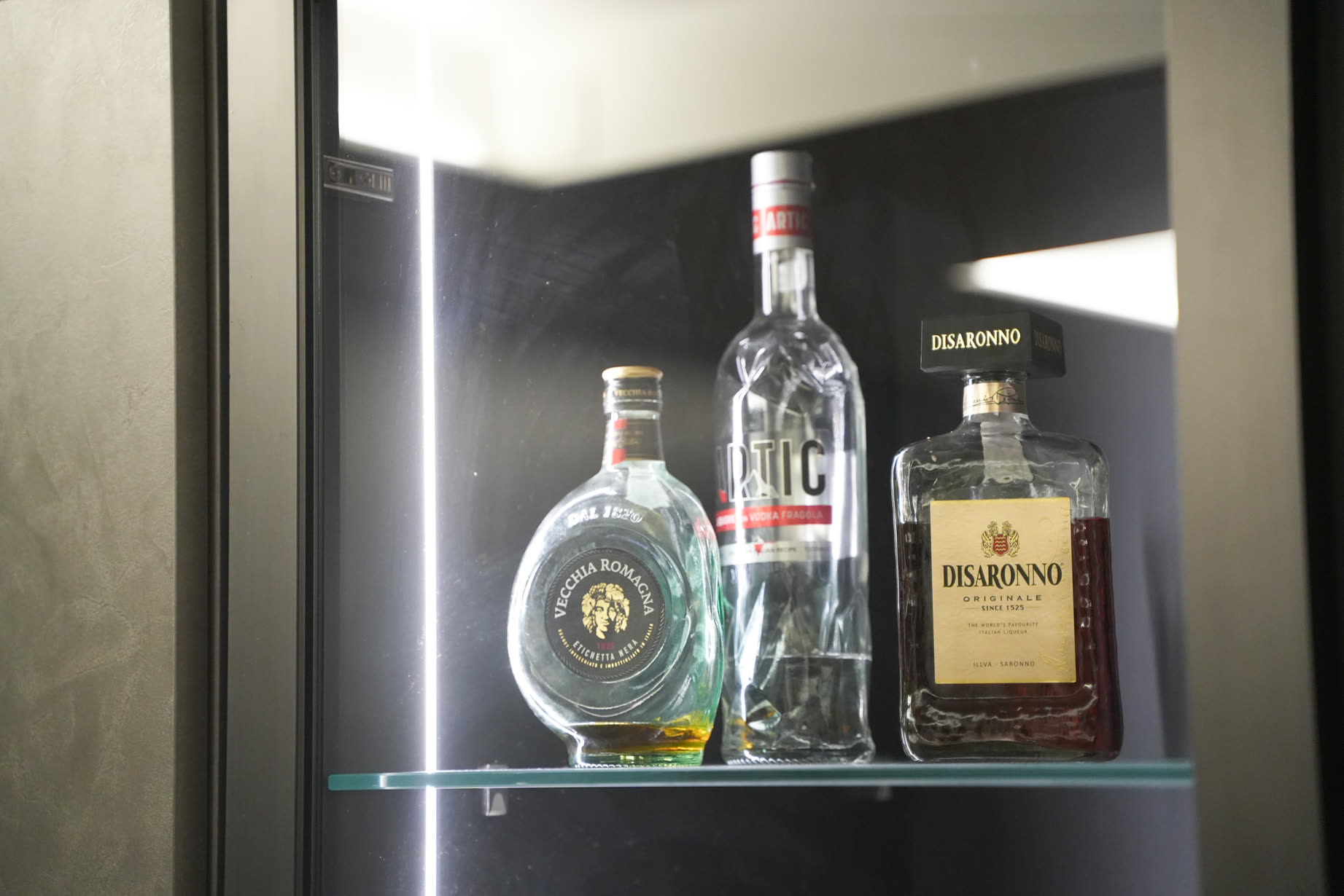 Mobile bar retroilluminato con bottiglie su fondo nero
