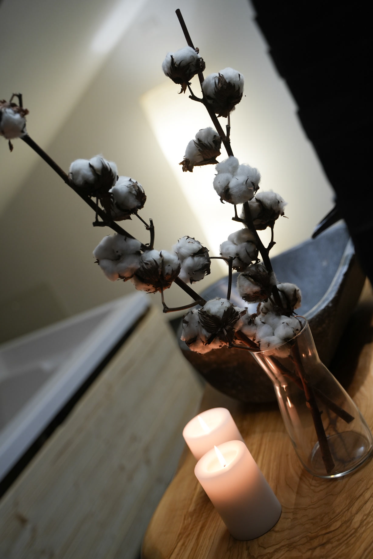 Ramo di cotone e candele accese nella penombra