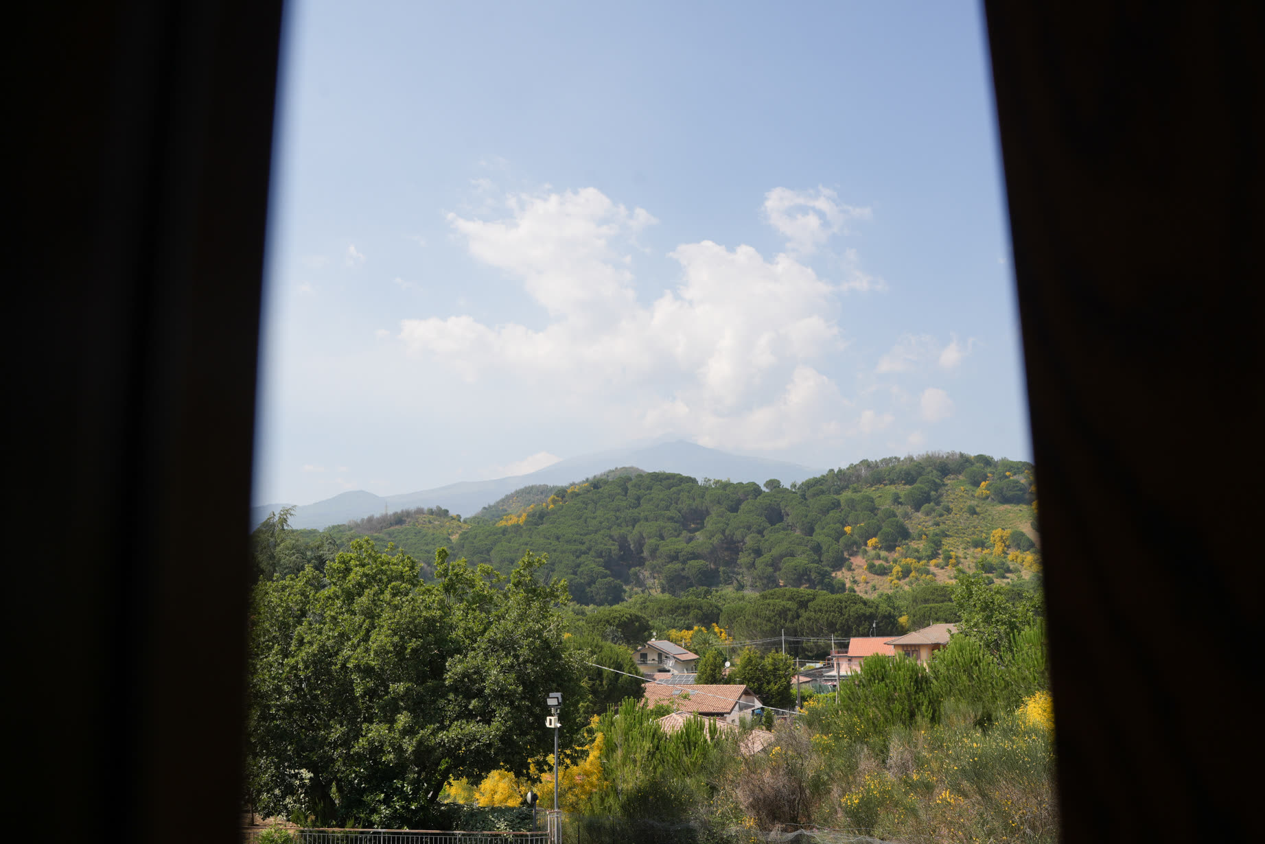 Vista dalla finestra della villa sulle colline verdi di Nicolosi, con cornice scura